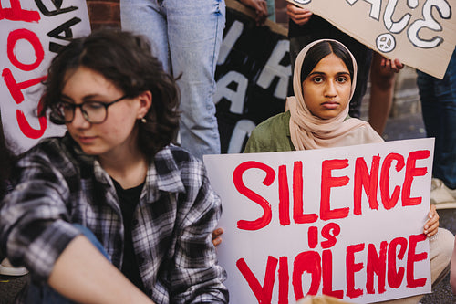 Young Muslim girl holding an anti-violence poster