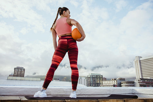 Athlete woman with basketball on rooftop