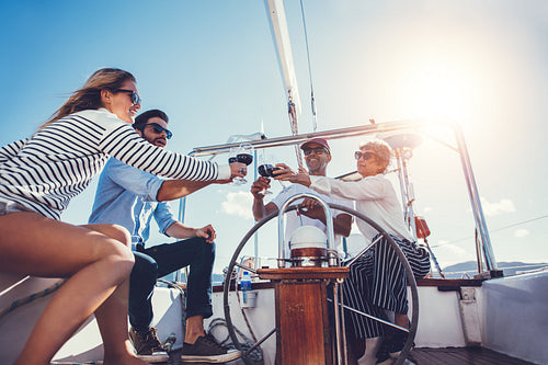 Happy family toasting wine glasses on a luxury yacht