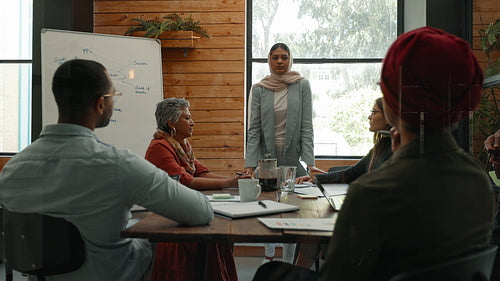 Woman in a hijab leading a team meeting in an office