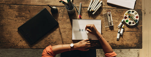 Black female designer drawing on a note pad