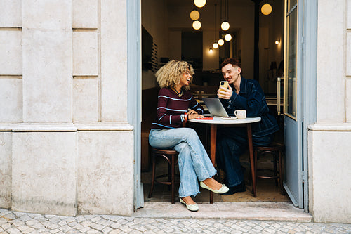 Young professionals and friends collaborating in a cafe