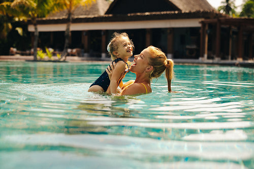 Joyful family moments in a pool during a sunny holiday