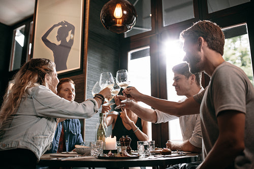 Group of friends toasting wine at cafe