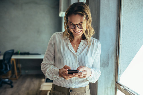 Businesswoman using her smart phone in office