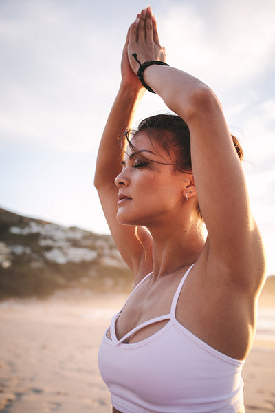 Woman meditating at the beach