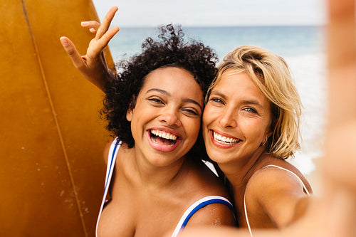 Fun beach memories: Female surfers smiling for a selfie on a surfing trip