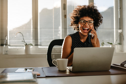 Laughing businesswoman sitting at her work desk