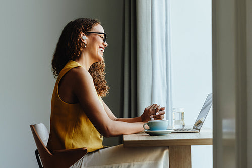 Happy african woman enjoys a video call with a client from her home office