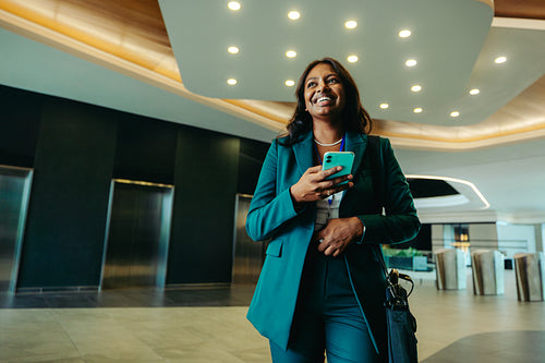 Confident professional woman walking in modern corporate lobby
