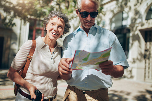 Mature man and woman using  map while sightseeing.