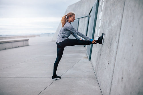 Young fitness woman stretching outdoors