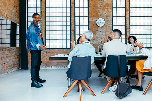Business meeting in a fresh and innovative office setting with diverse professionals clapping in appreciation