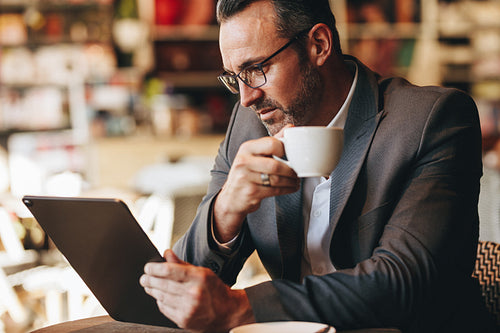 Business professional using digital tablet at coffee shop