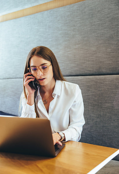 Focused young businesswoman making plans on a phone call