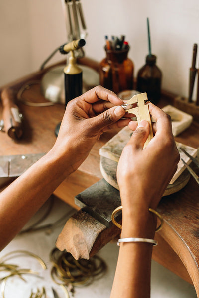 Artist hands measuring jewelry using vernier caliper