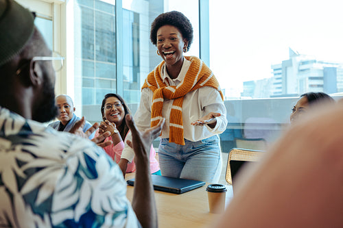 Diverse tech startup team in meeting with black woman leading discussion with enthusiasm