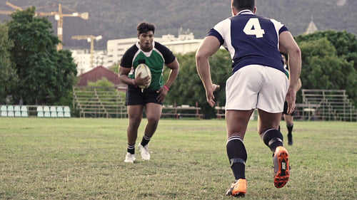 Rugby players tackling during game