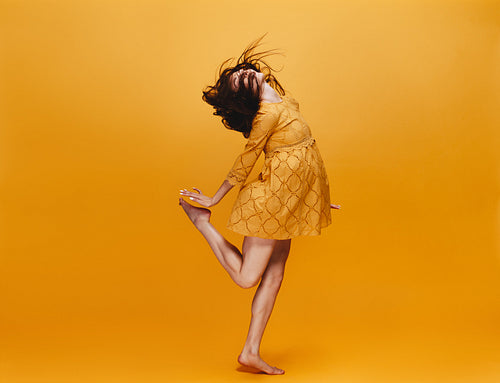 Woman dancing in orange dress