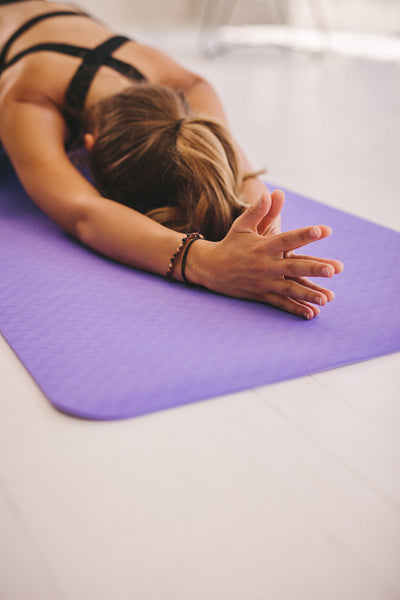 Woman doing balasana yoga at gym