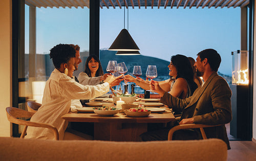 Friends enjoying dinner and drinks at a stylish evening gathering