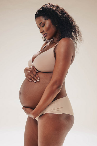 Pregnant African woman nurturing her growing baby bump