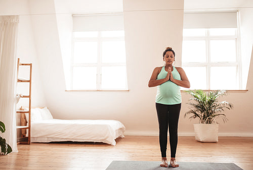 Pregnant woman doing yoga at home