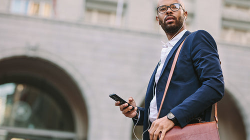 African businessman walking on city street