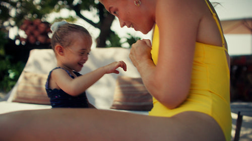 Mother and daughter sharing joyful moments and laughter playing a game during summer vacation