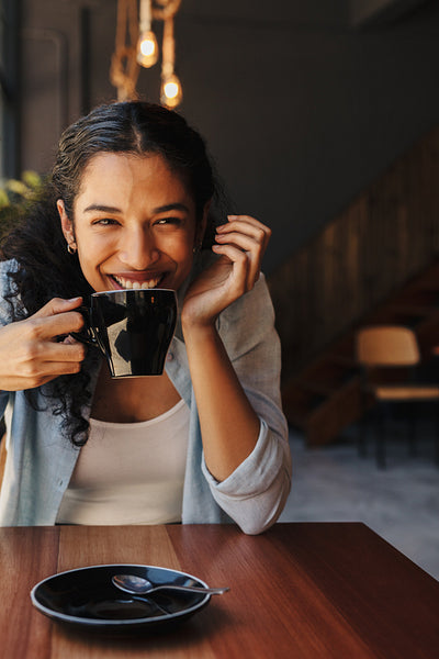 Smiling female drinking coffee in cafe