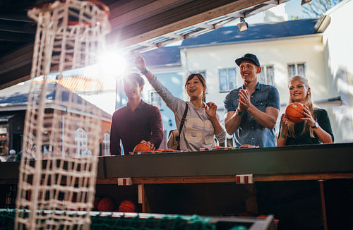 Happy young friends shooting hoops