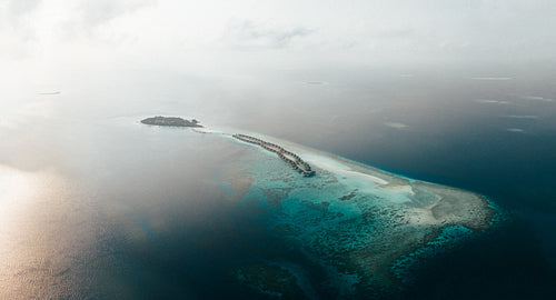 Tropical island resort in the Maldives surrounded by pristine ocean water and coral reefs