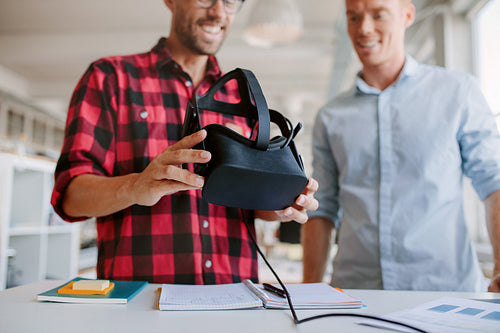 Two men using virtual reality goggles in office