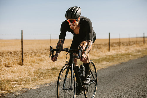 Determined cyclist riding bike on country road