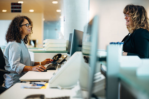 Woman talking with administration at reception desk