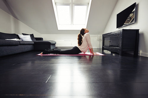 Pretty woman doing yoga exercise at home
