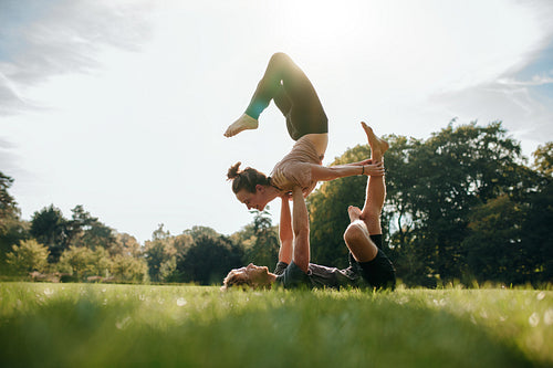 Couple doing acro yoga in park