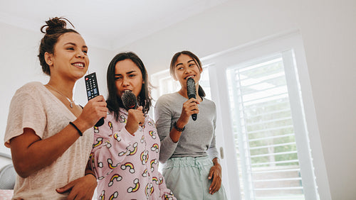 Girls having fun singing songs at a sleepover