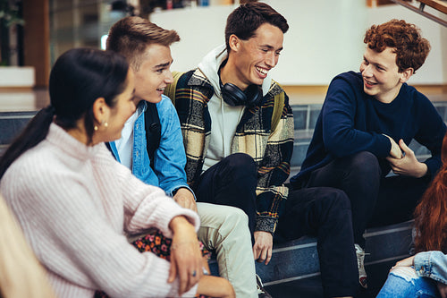 Cheerful young people hanging out in college