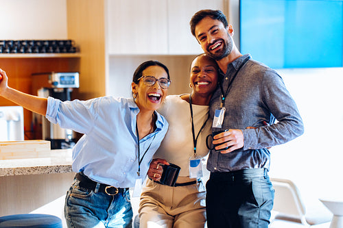 Group of colleagues smiling together during a casual break in the office