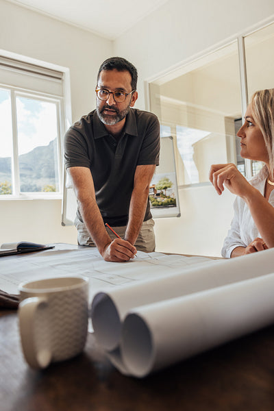 Architect leading a team discussion on design plans in a modern office