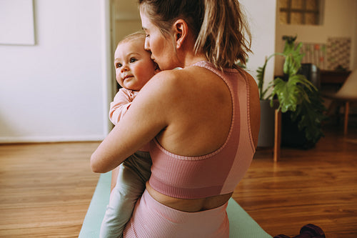 Loving mother kissing her baby at home