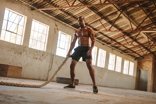 Muscular man working out in cross training gym