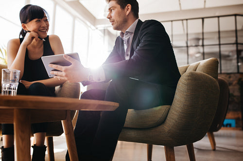 Young businesspeople using digital tablet in lobby