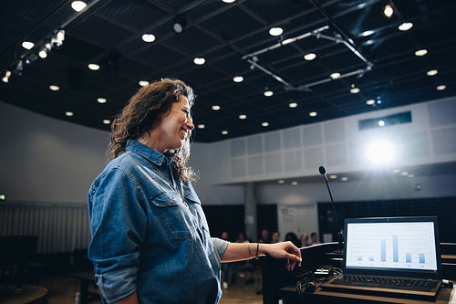 Successful businesswoman giving speech from podium