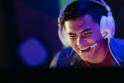Player smiling at his computer screen during an online video gaming session