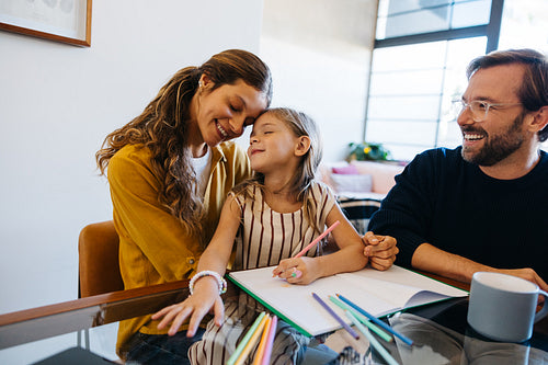 Mother, father and daughter study together at home