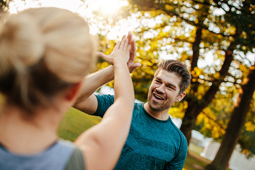 Fit young man giving high five to woman