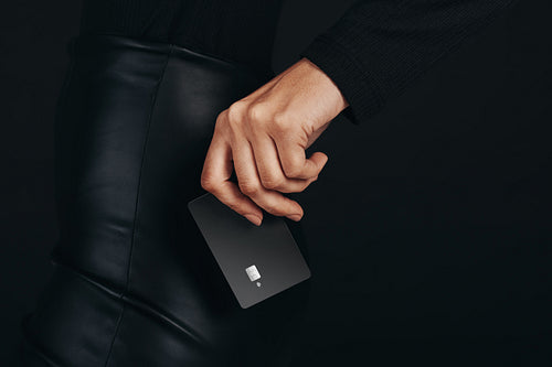 Getting a hold on the pulse of modern banking: Female hand holds a premium bank card in a studio setting