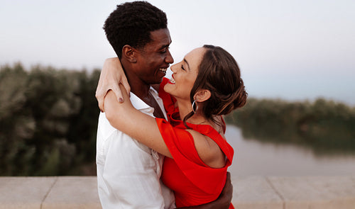 Cheerful couple embracing each other on a bridge